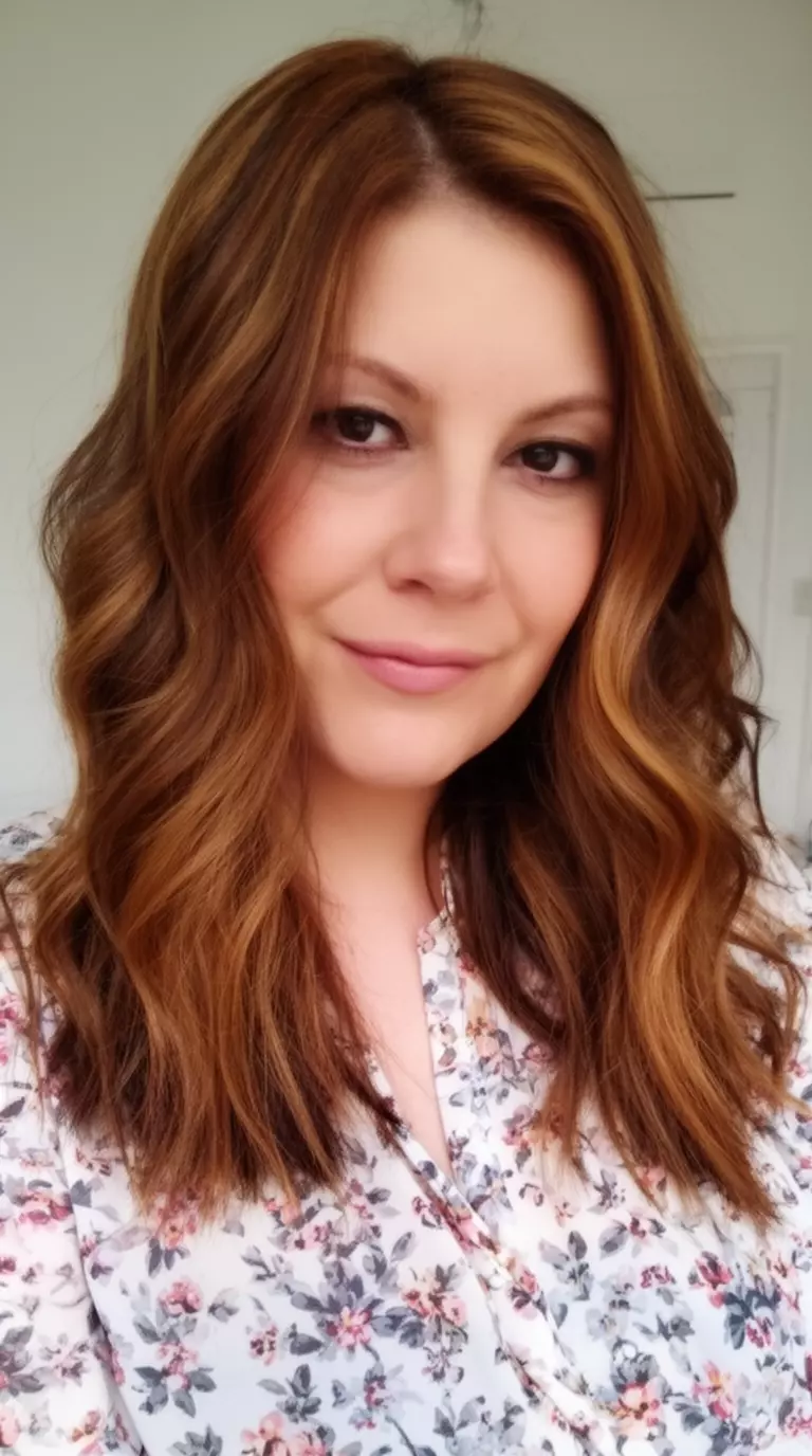 casual close-up photo of a 36-year-old woman wearing a floral blouse with a caramel glaze brown colored multi toned wavy hairstyle, slight side angle, minimal background
