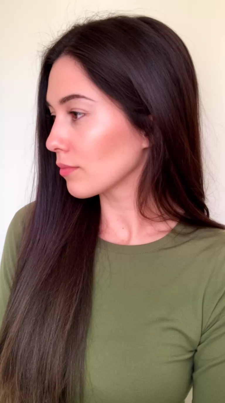 casual close-up photo of a 30-year-old woman wearing a long-sleeve olive top with a Tidal Wave Chocolate colored very long dark brown hairstyle, side profile view, minimal background