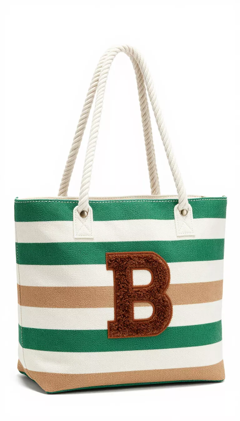 A green, white, and tan striped canvas tote bag featuring thick white rope handles and a large brown fluffy initial B appliqué on the front.
