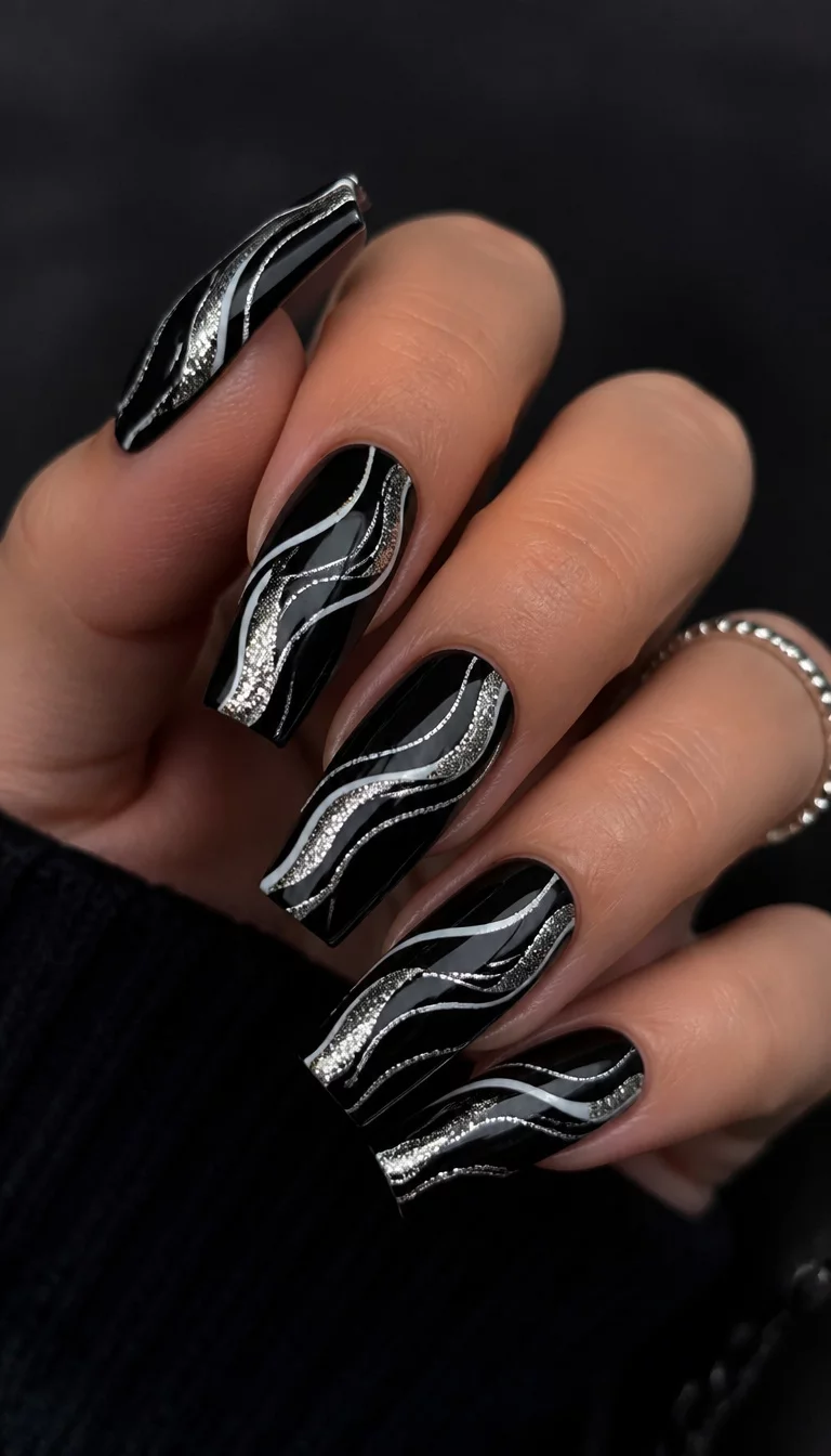 Silver Wave Square Extensions close-up shot of a woman’s hand with five fingers showing nails with long, square-shaped nails with a black base, white and silver wavy stripe designs and glitter accents, muted and dark background.