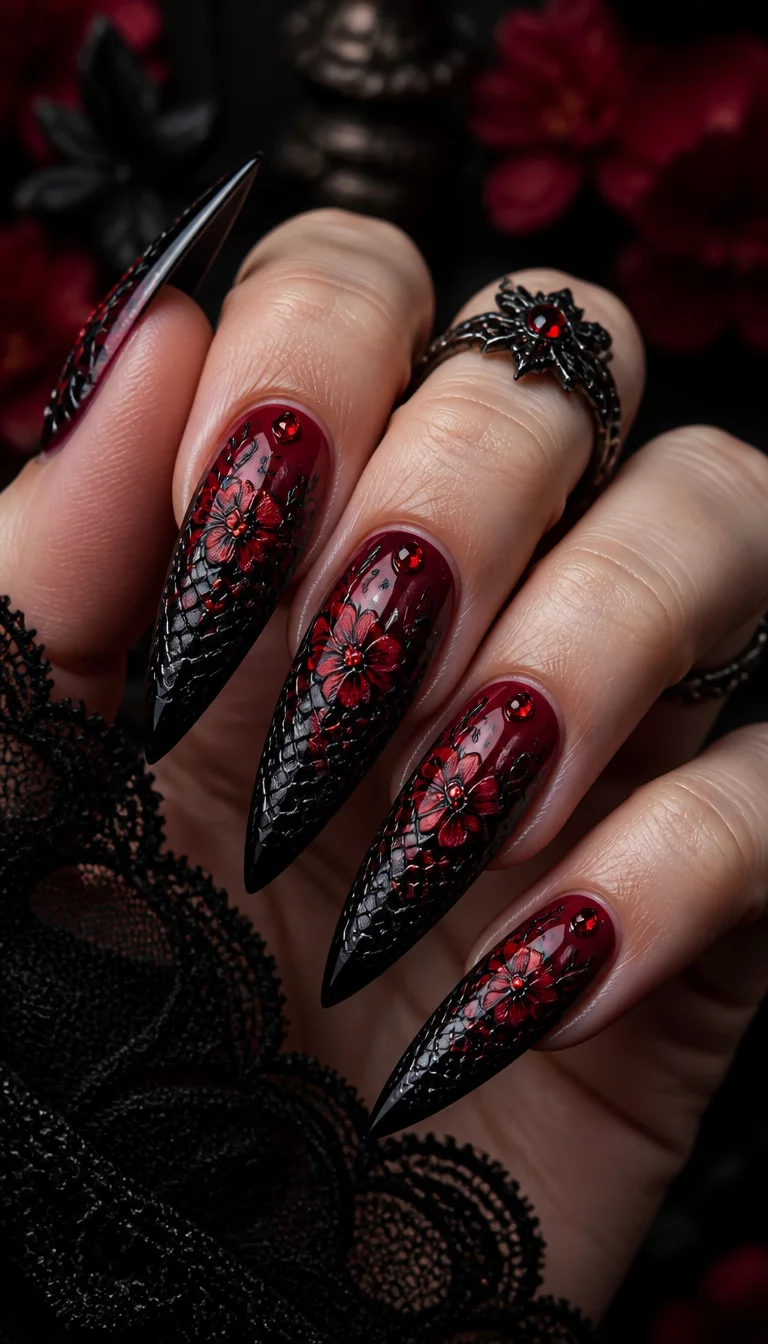 close-up shot of a woman’s hand with five fingers showing stiletto nails with a deep red to black gradient, featuring textured scale patterns, painted flowers, and small red gems, against a dark aesthetic background.