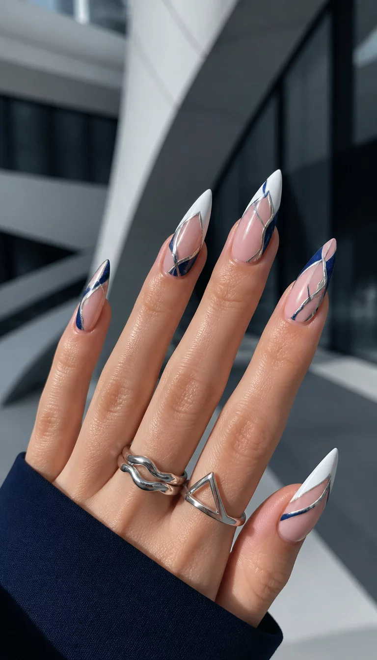 Navy And Silver Geometry close-up shot of a woman’s hand with five fingers showing nails with long pointed nails with white tips and navy blue accents, abstract silver shapes and lines, modern architectural background.
