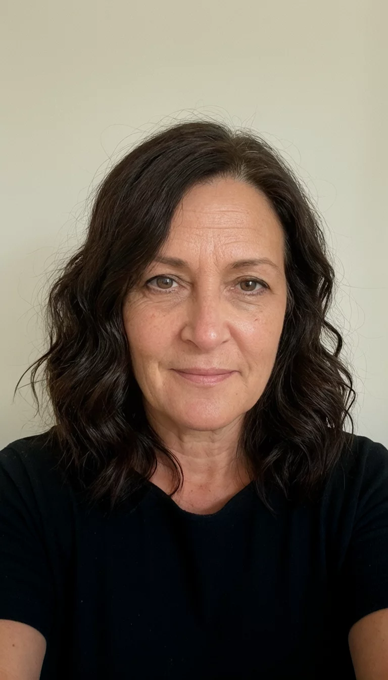 Espresso Bean Shine selfie of a 40-year-old woman wearing a black top with a dark espresso colored wavy hairstyle, front view, neutral backdrop