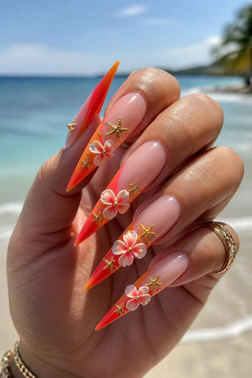 close-up shot of a woman’s hand with five fingers showing nails with extra-long sharp stiletto nails featuring an orange-red ombré French tip, 3D tropical flower and starfish decorations.