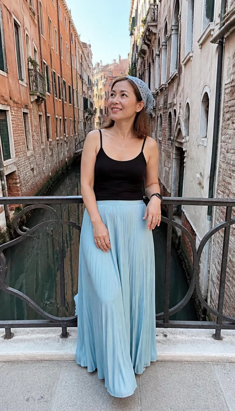 Black Tank Top And Flowing Skirt With Crochet Headscarf A photorealistic full body shot of a 47-year-old East Asian woman with a diamond face, dark brown, upturned nose, thick natural eyebrows, and full lips. Her face features gap between front teeth, subtle acne marks, and subtle natural facial asymmetry. She has round blue eyes, high cheekbones, broad smile, thoughtful. She is average build with brown hair hair and is wearing a light blue crochet headscarf, a black tank top, and a flowing skirt, bridge overlooking narrow historic buildings and a canal, no people in the background, high-quality mobile photography, shot on an iPhone 14.